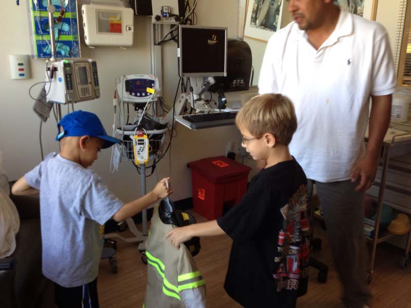 Nico Castro giving out Halloween costumes to other kids at the hospital