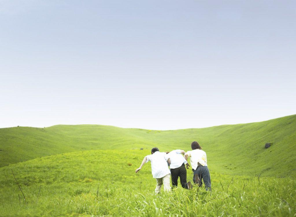 People helping walk through a field