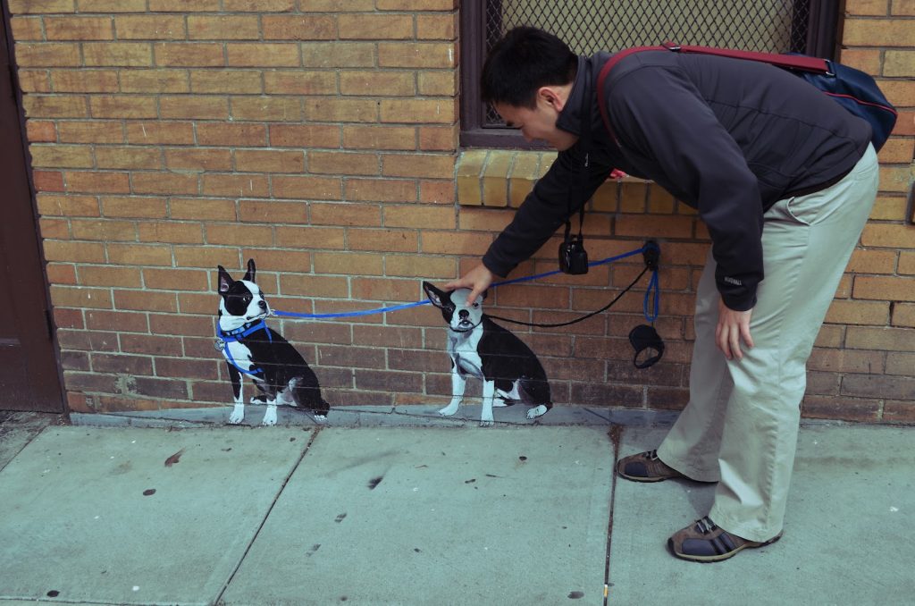 Toan Lam "petting" a painting of a dog